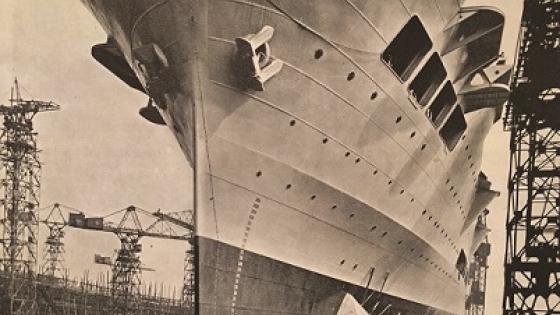 The moment Ark Royal was launched on Merseyside, 13 April 1937. Her bows tower up to the flight deck, which is 800 feet long and 94 feet wide. She cost £2,330,000.
